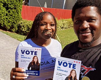 Two people holding voter outreach materials