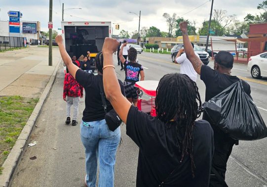 Community members waving during a neighborhood event