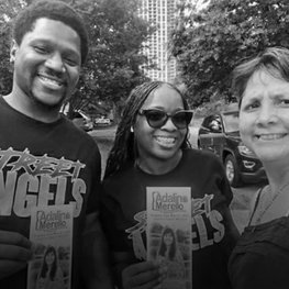 Three people holding community outreach flyers